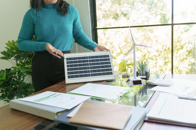 Close-up shot of a hand signing a document related to a renewable energy project, with other documents and a laptop displaying energy data in the background.
