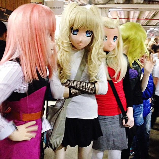 A busy convention scene featuring attendees dressed in elaborate anime cosplay, showcasing intricate costumes and props. The atmosphere is lively and filled with excitement, reflecting the vibrant community surrounding anime culture.