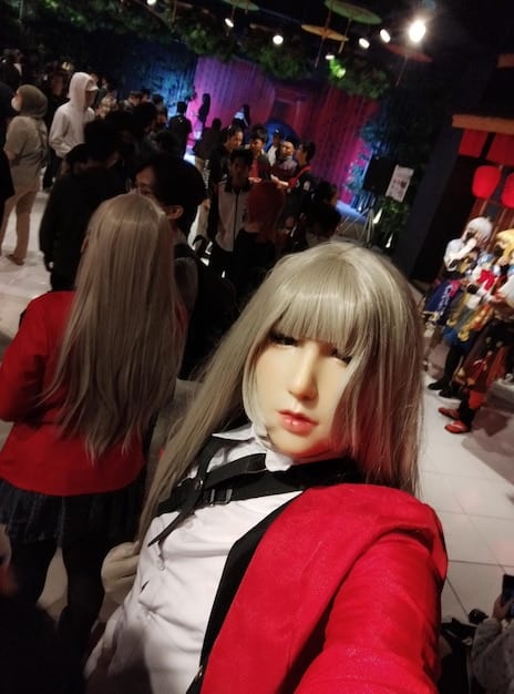 A split image: On one side, a bustling anime convention scene with cosplayers and merchandise booths. On the other side, a screenshot of a vibrant Discord server dedicated to anime, showing active text channels, voice channels, and user avatars. This juxtaposition illustrates the connection between online and offline anime communities.