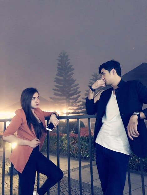 A still from a popular K-Drama, showing a male lead and female lead in a romantic scene, with soft lighting and vibrant background.