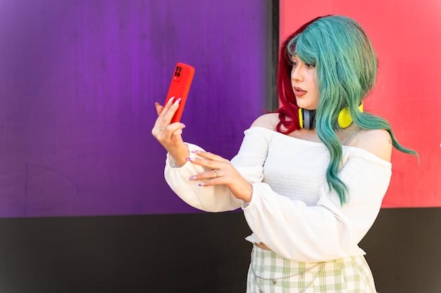 A young woman in elaborate anime cosplay posing for a photo at a convention. She is holding a smartphone and smiling, with a backdrop of colorful anime-themed decorations.