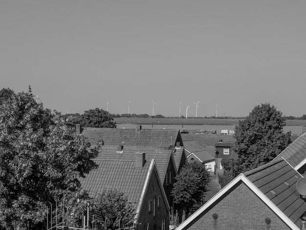 A split image showing solar panels on a residential roof on one side and wind turbines in a commercial field on the other, symbolizing renewable energy credits for homes and businesses.