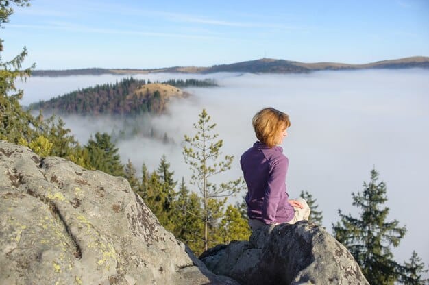 A person sitting on a mountaintop, meditating and looking out at a vast landscape, representing the freedom and flexibility that can come with choosing an uncategorized lifestyle.